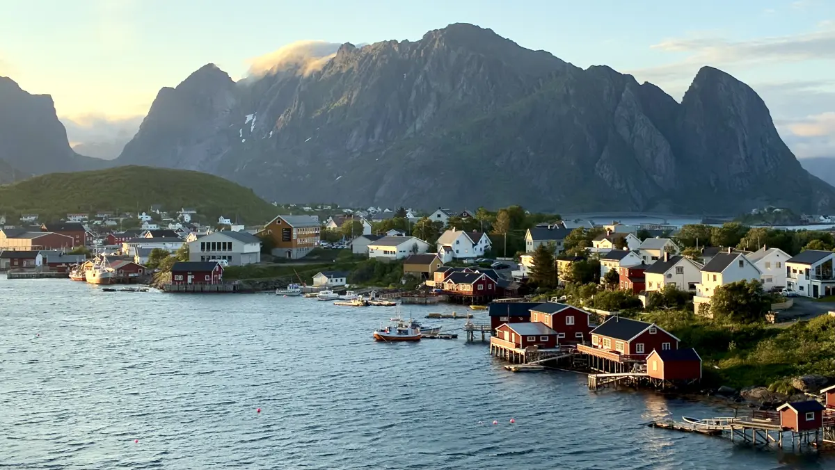 从挪威国家旅游公路罗弗敦之路上的 Reinehalsen 观景点欣赏午夜阳光下的雷讷 (Reine)